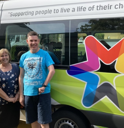 Rachelle and Daniel photo in front of liberty community bus talking about creating an independent life doing what you love