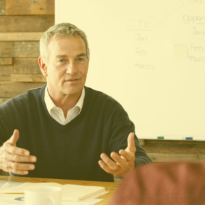 a man sitting at a desk providing positive feedback to another person just out of shot