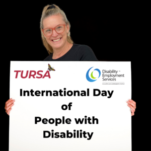 TURSA employee holding a sign that reads International Day of People with Disability IDPwD