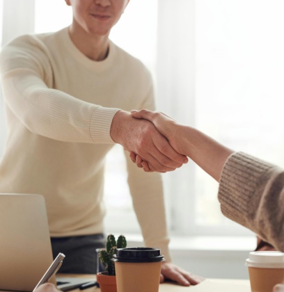 Man Shaking A Womans Hand Across A Table During An Interview